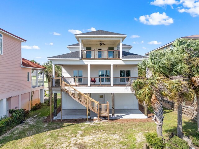 rear view of property with ceiling fan, a porch, a yard, a patio, and a balcony