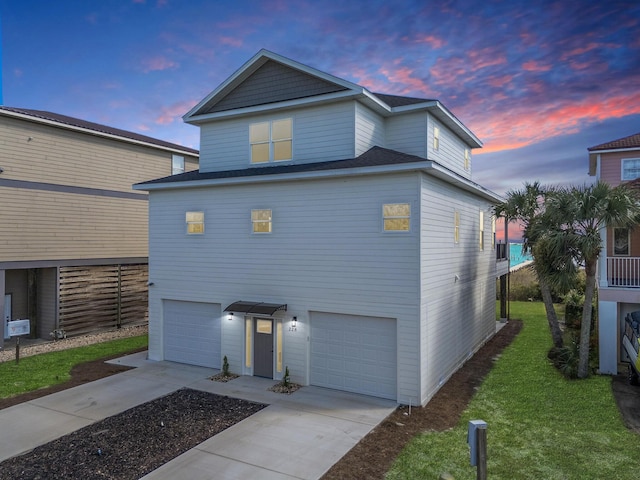 view of front of home with a garage and a lawn