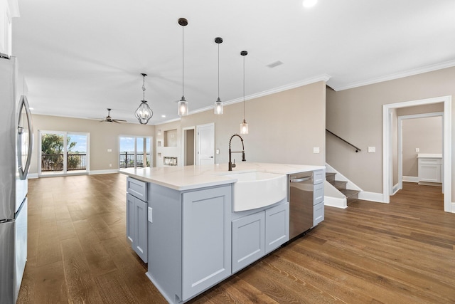 kitchen with dark wood-type flooring, sink, decorative light fixtures, an island with sink, and stainless steel appliances