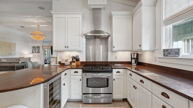 kitchen with stainless steel range with electric cooktop, beverage cooler, wall chimney exhaust hood, and dark stone counters