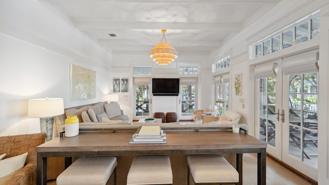 living room with french doors, hardwood / wood-style floors, an inviting chandelier, and beam ceiling