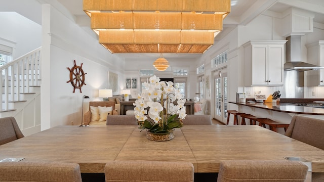 dining room with a high ceiling, a healthy amount of sunlight, and beamed ceiling