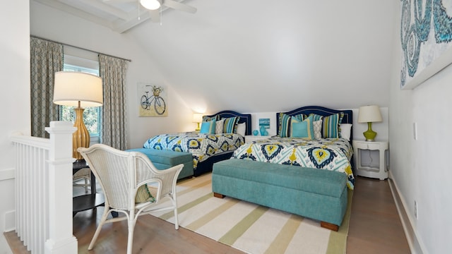 bedroom featuring ceiling fan, hardwood / wood-style floors, and vaulted ceiling with beams