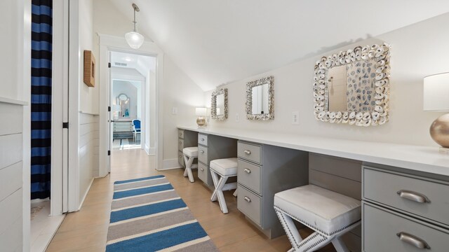 bathroom with hardwood / wood-style flooring, vanity, and vaulted ceiling