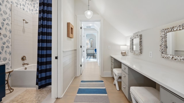 bathroom with hardwood / wood-style flooring, shower / tub combo, vaulted ceiling, and vanity