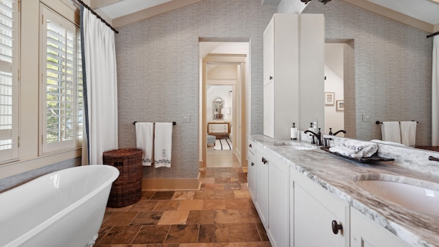 bathroom featuring a washtub, vaulted ceiling with beams, and vanity