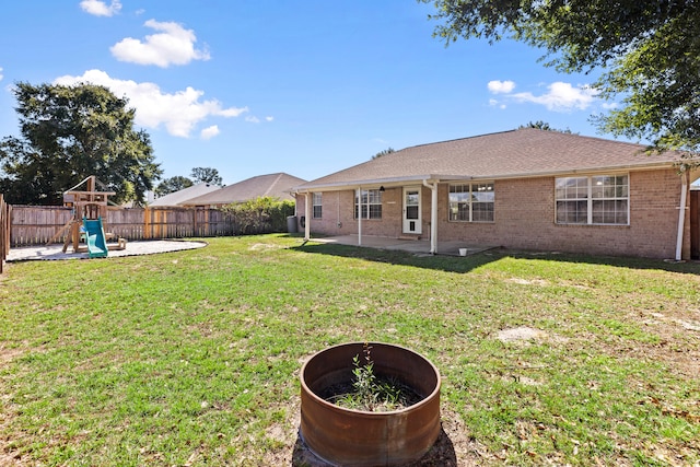 rear view of house featuring a yard, a playground, and a patio area