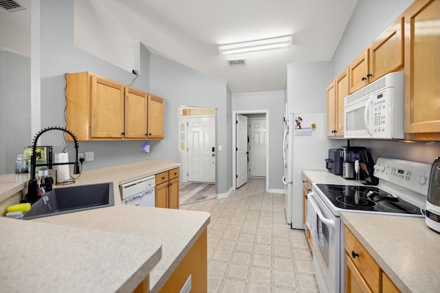 kitchen with a textured ceiling, sink, white appliances, and light brown cabinets