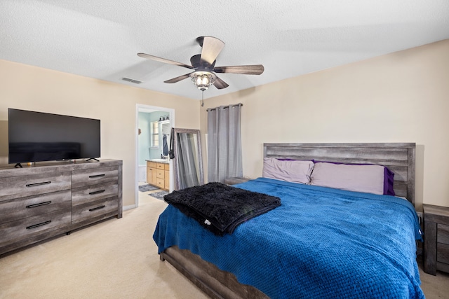 carpeted bedroom featuring connected bathroom, ceiling fan, and a textured ceiling