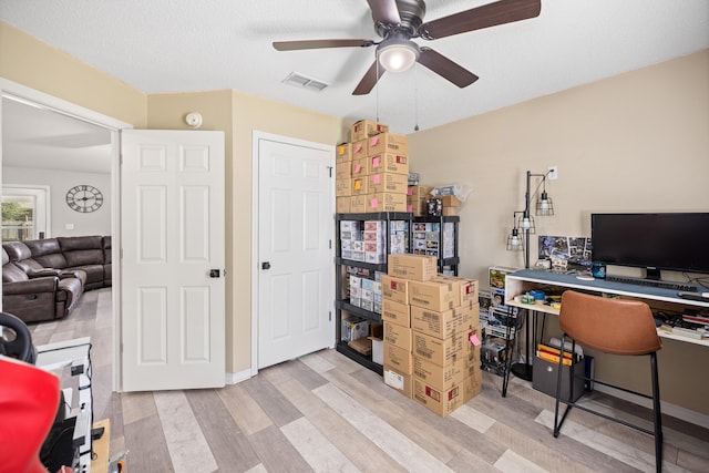 office featuring ceiling fan, light hardwood / wood-style floors, and a textured ceiling