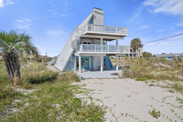 back of property featuring a deck and a patio