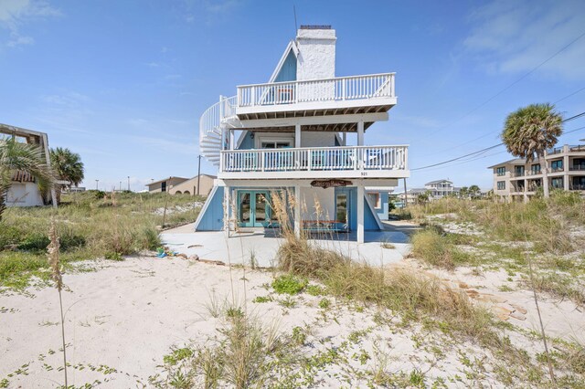 rear view of property featuring a wooden deck and a patio area