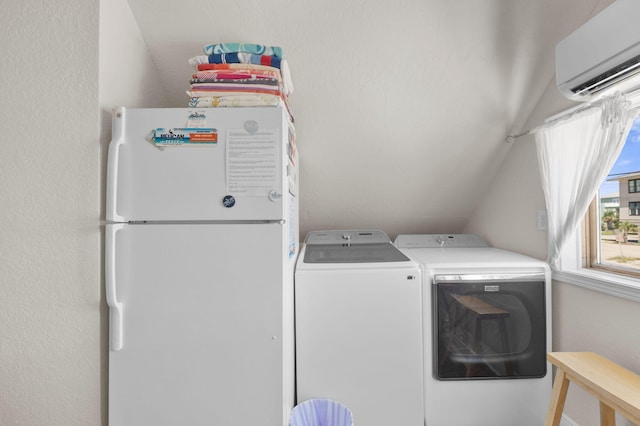 washroom with an AC wall unit and washing machine and clothes dryer