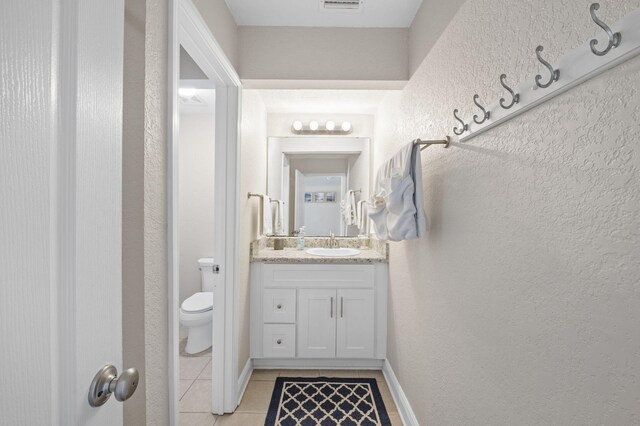 bathroom featuring vanity, toilet, and tile patterned floors