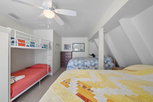 bedroom featuring ceiling fan, tile patterned floors, and a textured ceiling