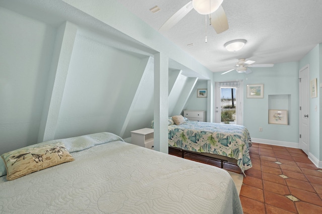 bedroom with ceiling fan, a textured ceiling, and tile patterned floors