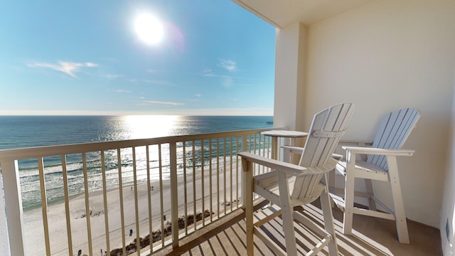 balcony featuring a water view and a beach view