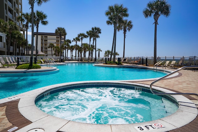 view of swimming pool featuring a hot tub