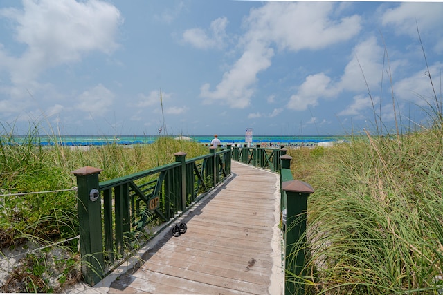 dock area with a water view and a view of the beach