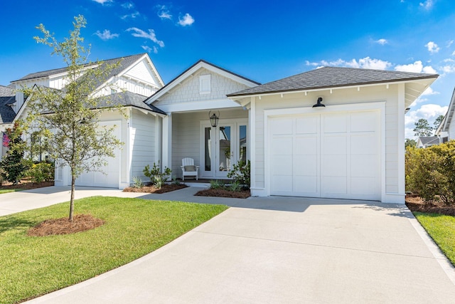 view of front of home with a front lawn, covered porch, and a garage