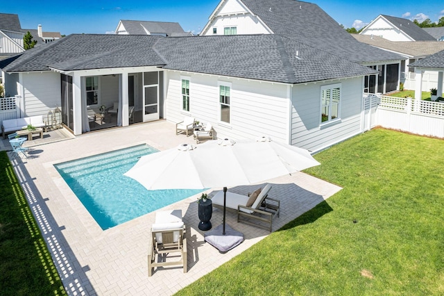 back of property featuring a patio, a yard, and a fenced in pool