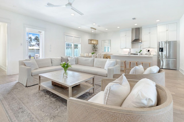 living room with ceiling fan and light hardwood / wood-style floors