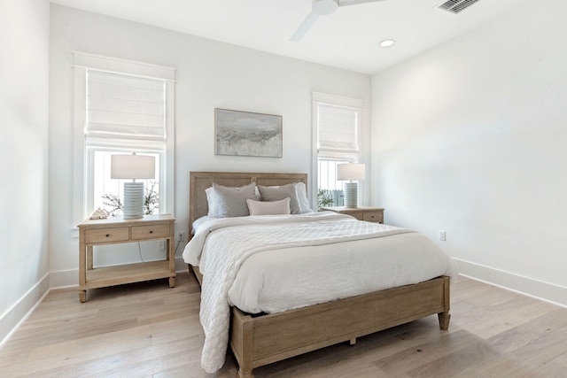 bedroom featuring multiple windows, ceiling fan, and light hardwood / wood-style flooring