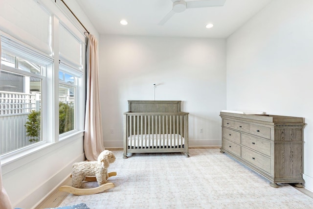 bedroom featuring ceiling fan and a crib