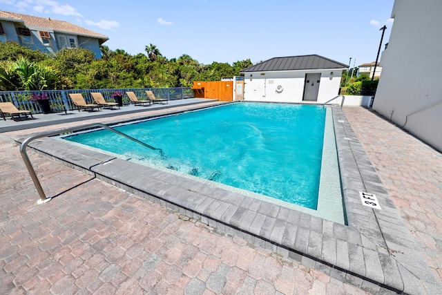 pool with fence and a patio