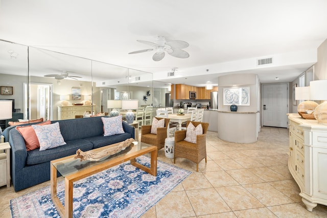living room with light tile patterned floors, visible vents, and a ceiling fan