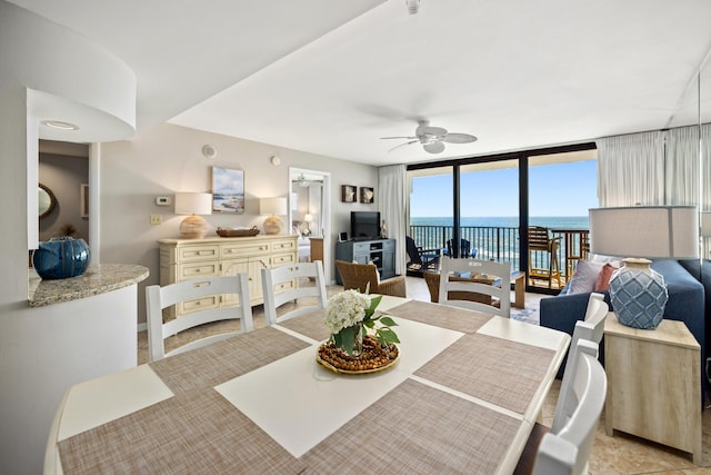 dining space with a ceiling fan and expansive windows