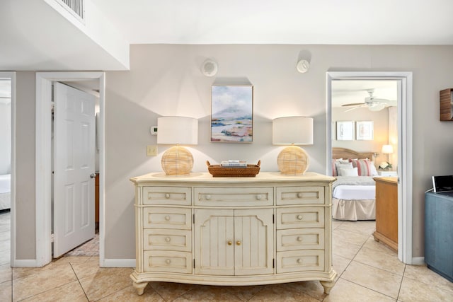 interior space with tile patterned floors, connected bathroom, and a ceiling fan