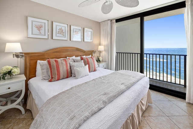 bedroom with a wall of windows, access to exterior, a water view, and light tile patterned flooring