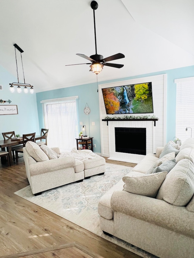 living room with lofted ceiling, a fireplace, hardwood / wood-style floors, and ceiling fan