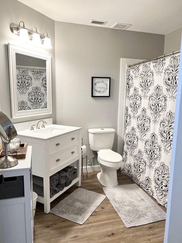 bathroom with hardwood / wood-style floors, vanity, and toilet