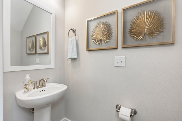 bathroom with lofted ceiling and sink