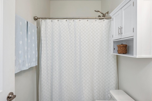 bathroom featuring a shower with curtain and toilet