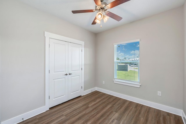 unfurnished bedroom featuring dark hardwood / wood-style floors, ceiling fan, and a closet