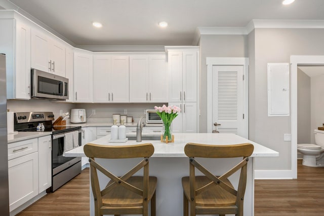 kitchen featuring appliances with stainless steel finishes, dark hardwood / wood-style floors, and white cabinets