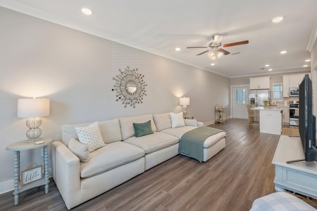 living room featuring ceiling fan, ornamental molding, and hardwood / wood-style floors