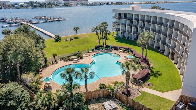 view of swimming pool with a yard and a water view