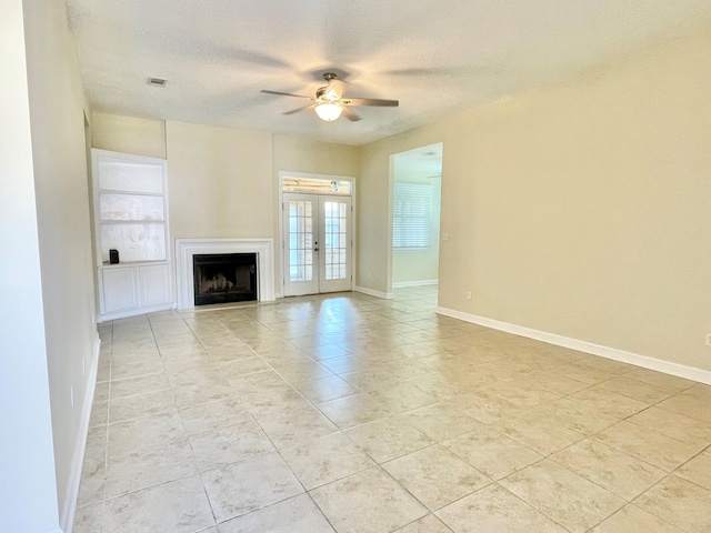 unfurnished living room featuring a textured ceiling, light tile patterned floors, ceiling fan, and french doors