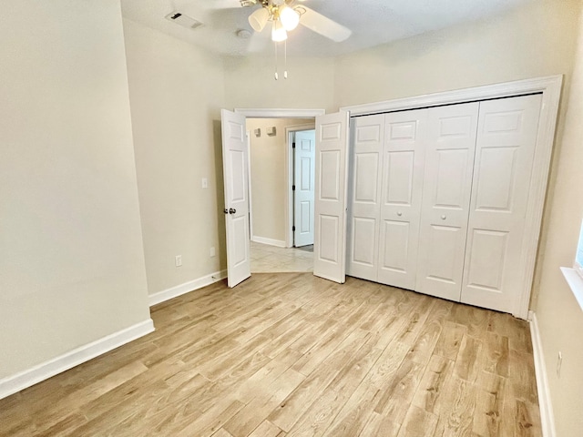 unfurnished bedroom featuring a closet, light hardwood / wood-style floors, and ceiling fan