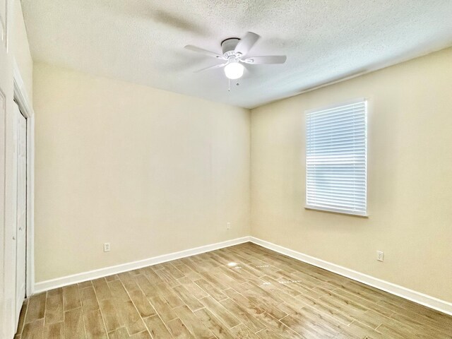 unfurnished bedroom with a textured ceiling, ceiling fan, a closet, and light hardwood / wood-style flooring