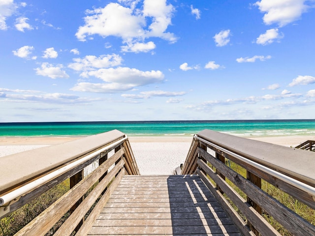 view of property's community featuring a water view and a beach view