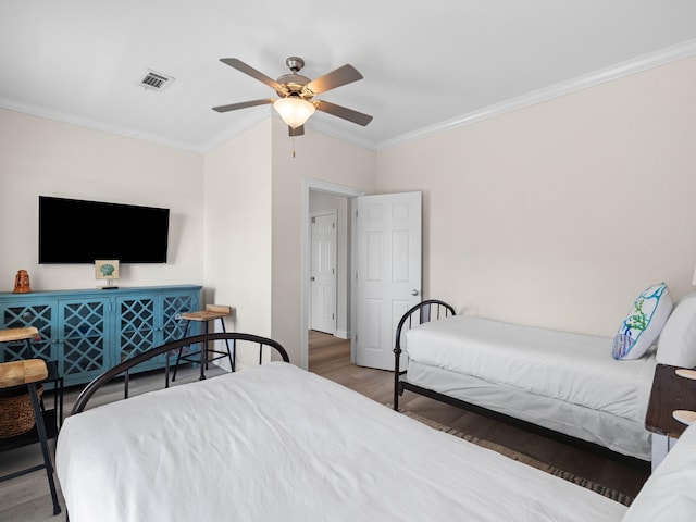 bedroom with wood-type flooring, crown molding, and ceiling fan