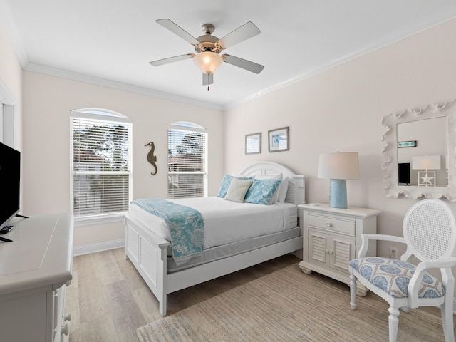 bedroom with light wood-type flooring, ceiling fan, and crown molding