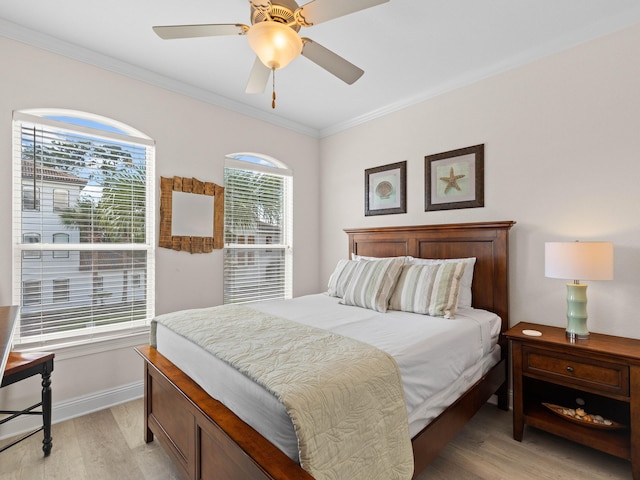 bedroom with ceiling fan, crown molding, and light hardwood / wood-style floors