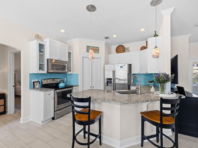 kitchen featuring appliances with stainless steel finishes, kitchen peninsula, a kitchen bar, and decorative light fixtures