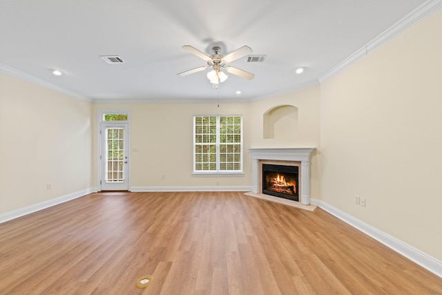 unfurnished living room featuring ceiling fan, a fireplace, crown molding, and light hardwood / wood-style floors